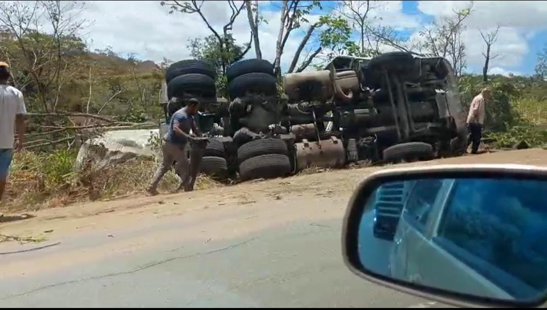 Caminhão com carga de cimento sai de pista e tomba na BR-101, em Teotônio
